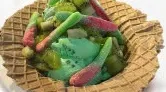 Canasta de galleta con helado y gomitas.